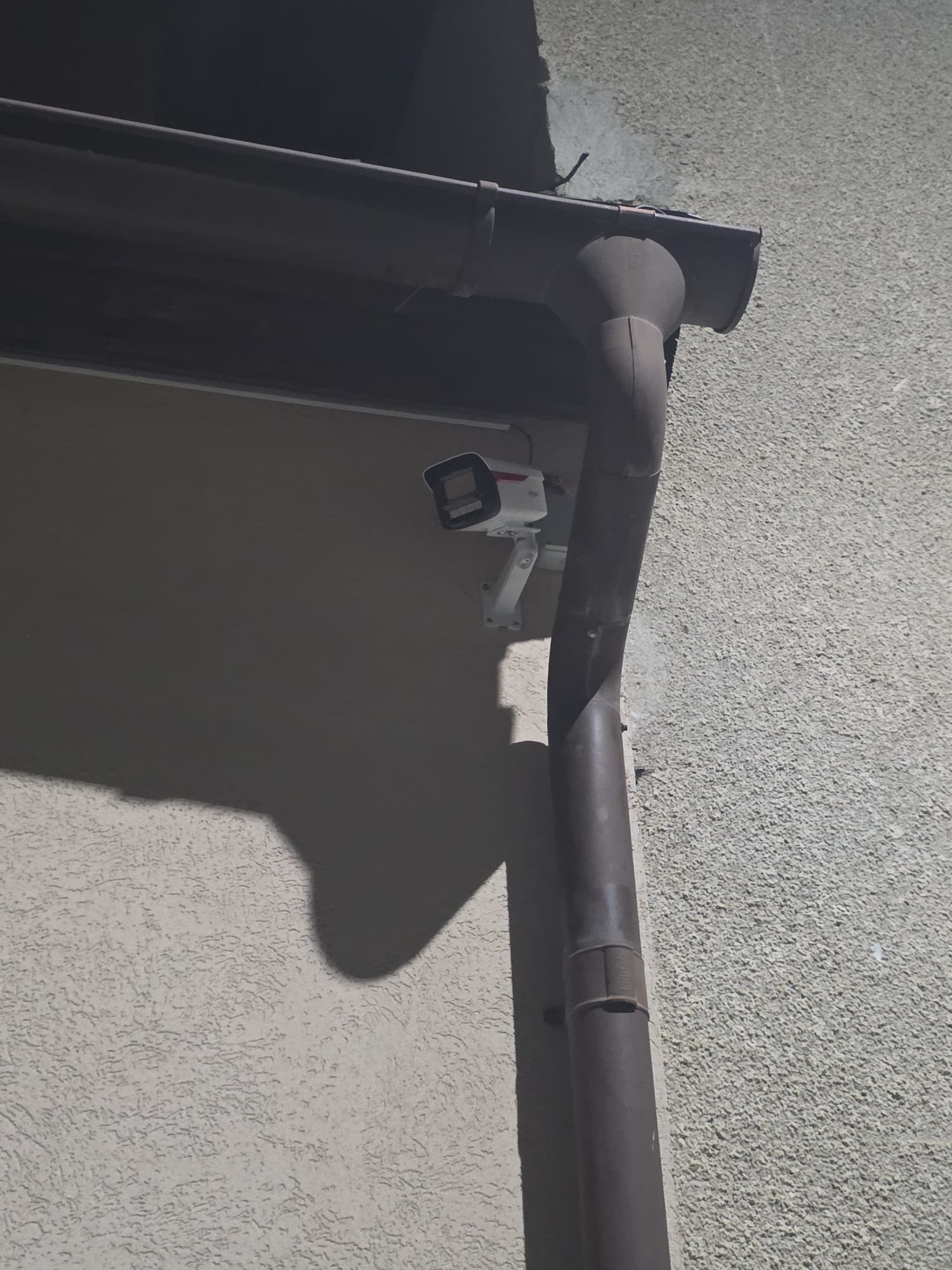 Cameră bullet Hikvision montată pe fațada unei case din județul Sibiu, lângă burlan