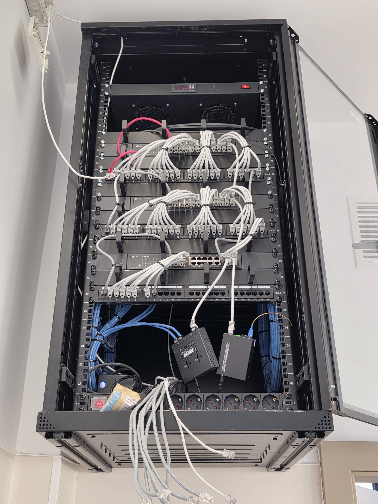 Rack de rețelistică cu switch-uri TP-Link, patch panel Cat.6 și cablare structurată organizată