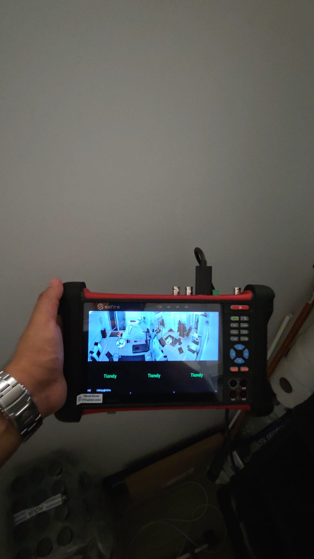 Tehnician verificând camerele Tiandy cu tester video Safire în timpul punerii în funcțiune a sistemului