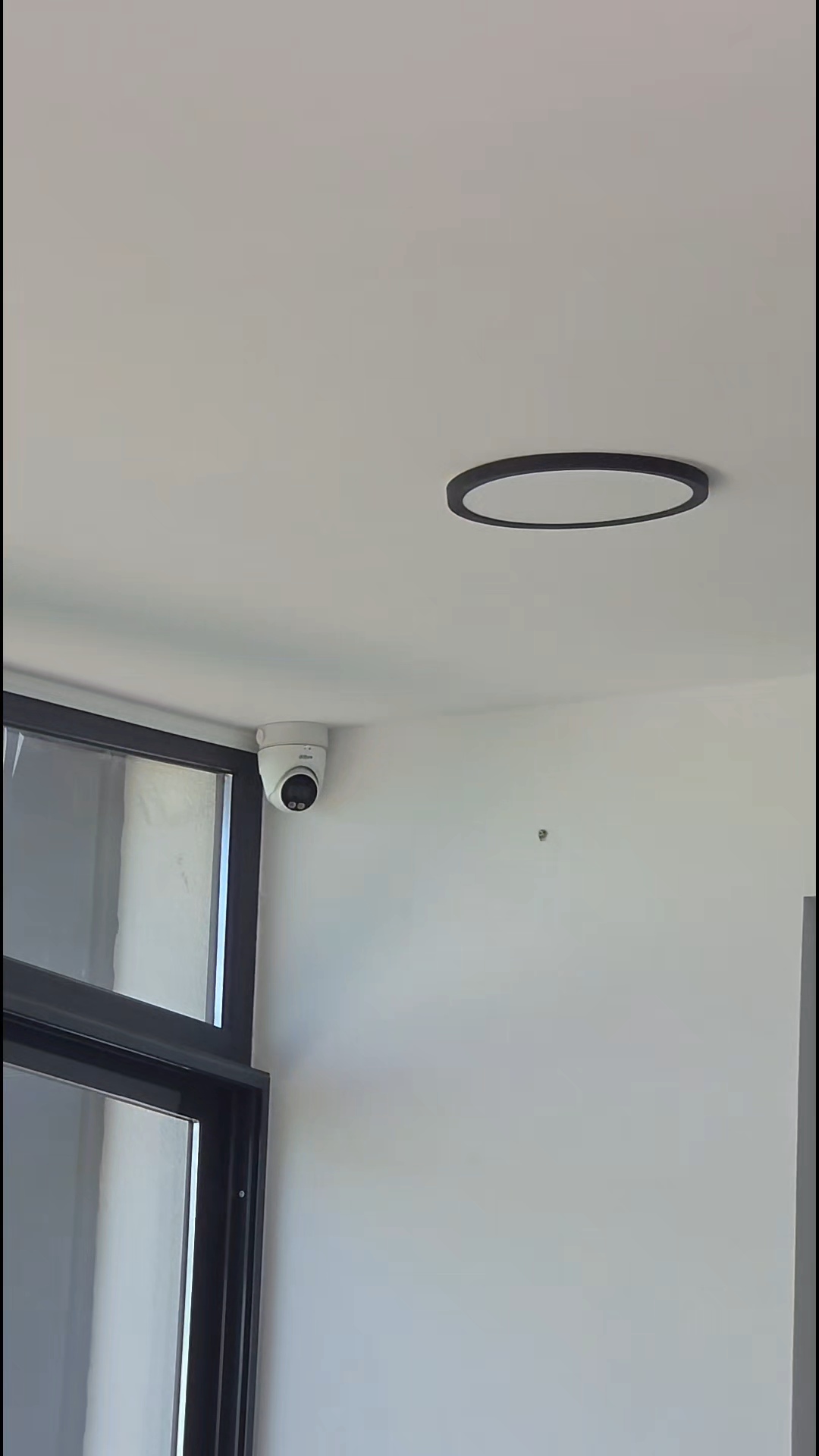 Cameră Dahua dome montată în colțul tavanului unei locuințe, lângă fereastră